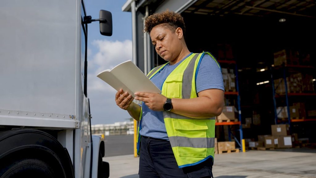 Warehouse worker reading rights booklet in warehouse