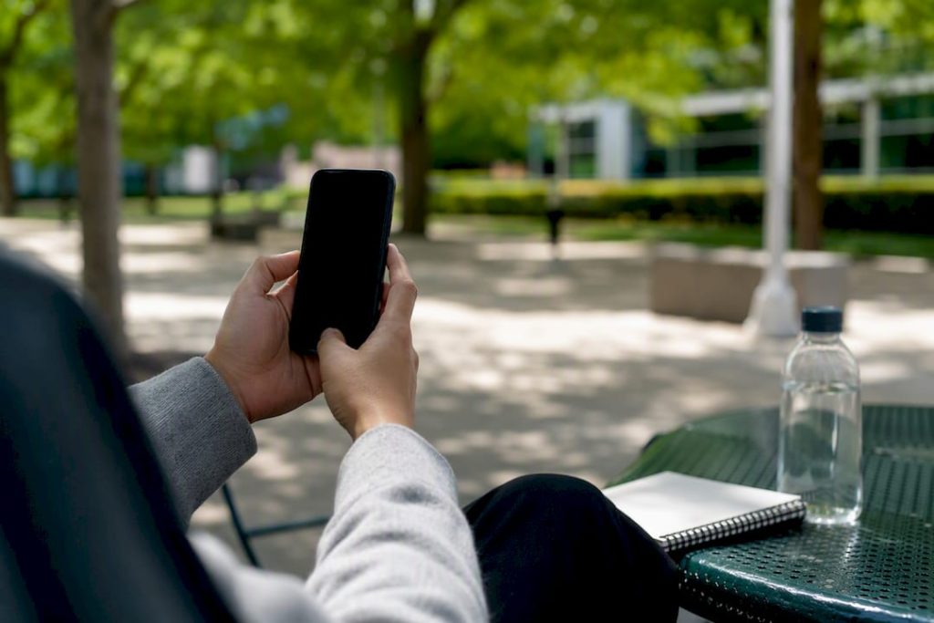 Hands holding smartphone to document